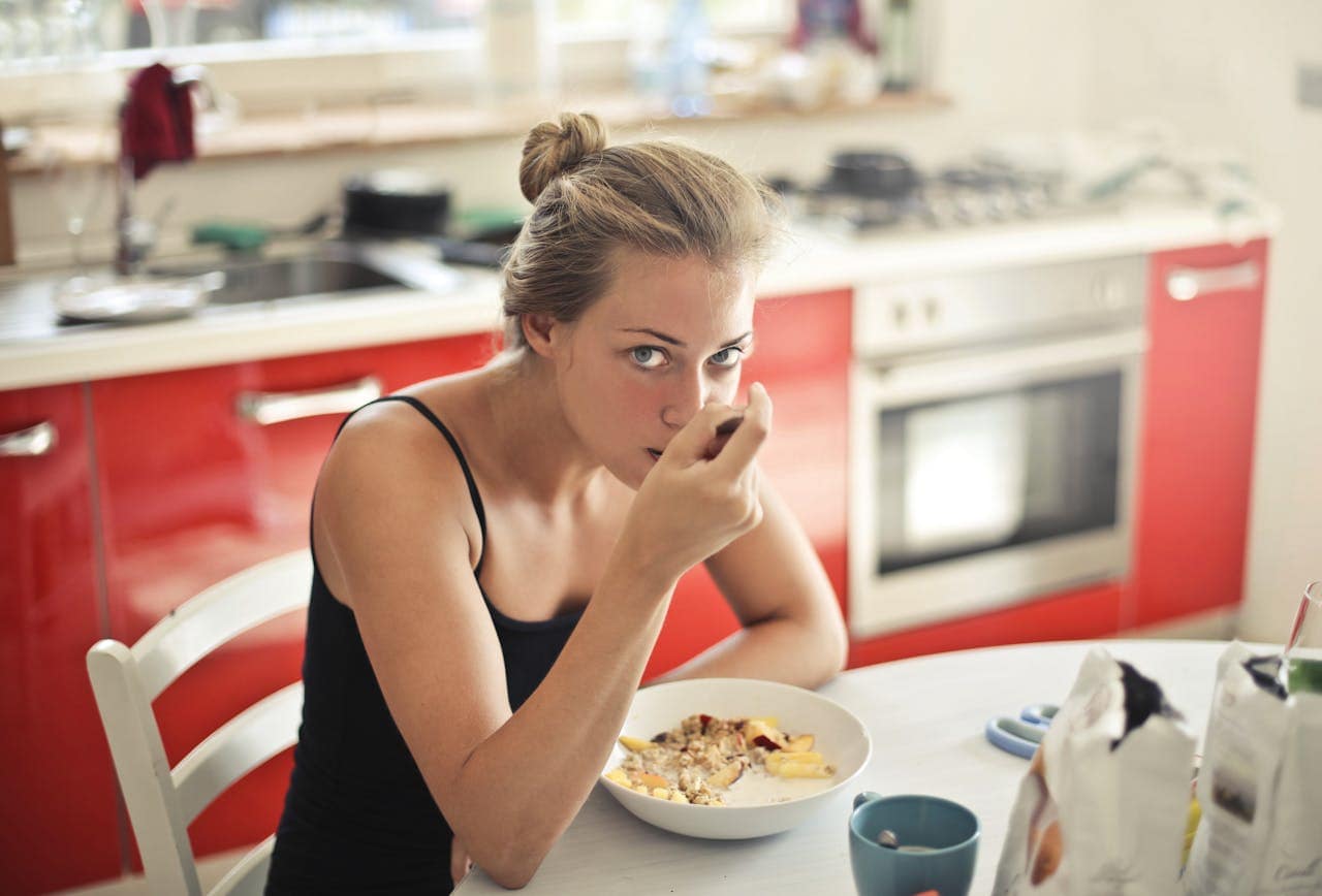 ragazza bionda che fa colazione con i cereali